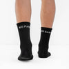 Black socks with 'No Pain No Gain' text worn by a person on a white background