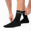 Black socks with 'Discipline' branding worn by a person on a white background