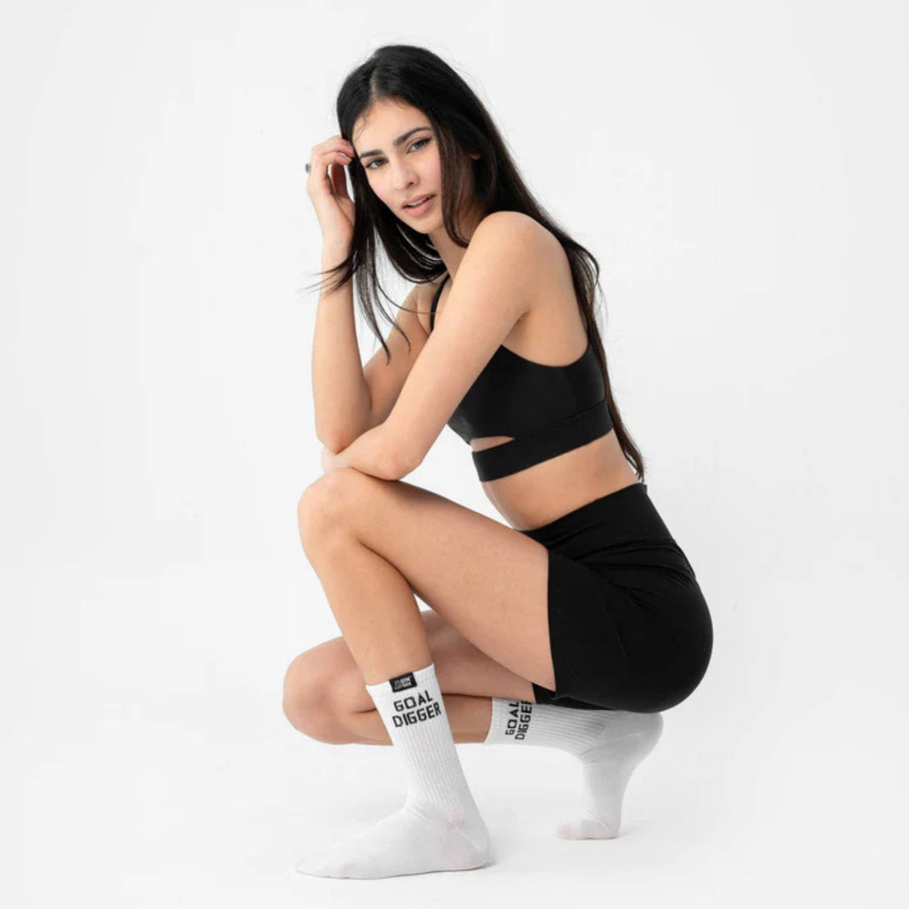 Woman wearing black athletic outfit and white socks with text on a white background