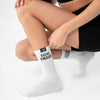 Person wearing white socks with 'GOAL DIGGER' text on a light background