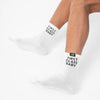 White socks with 'First Class Baby' text worn by a person on a white background