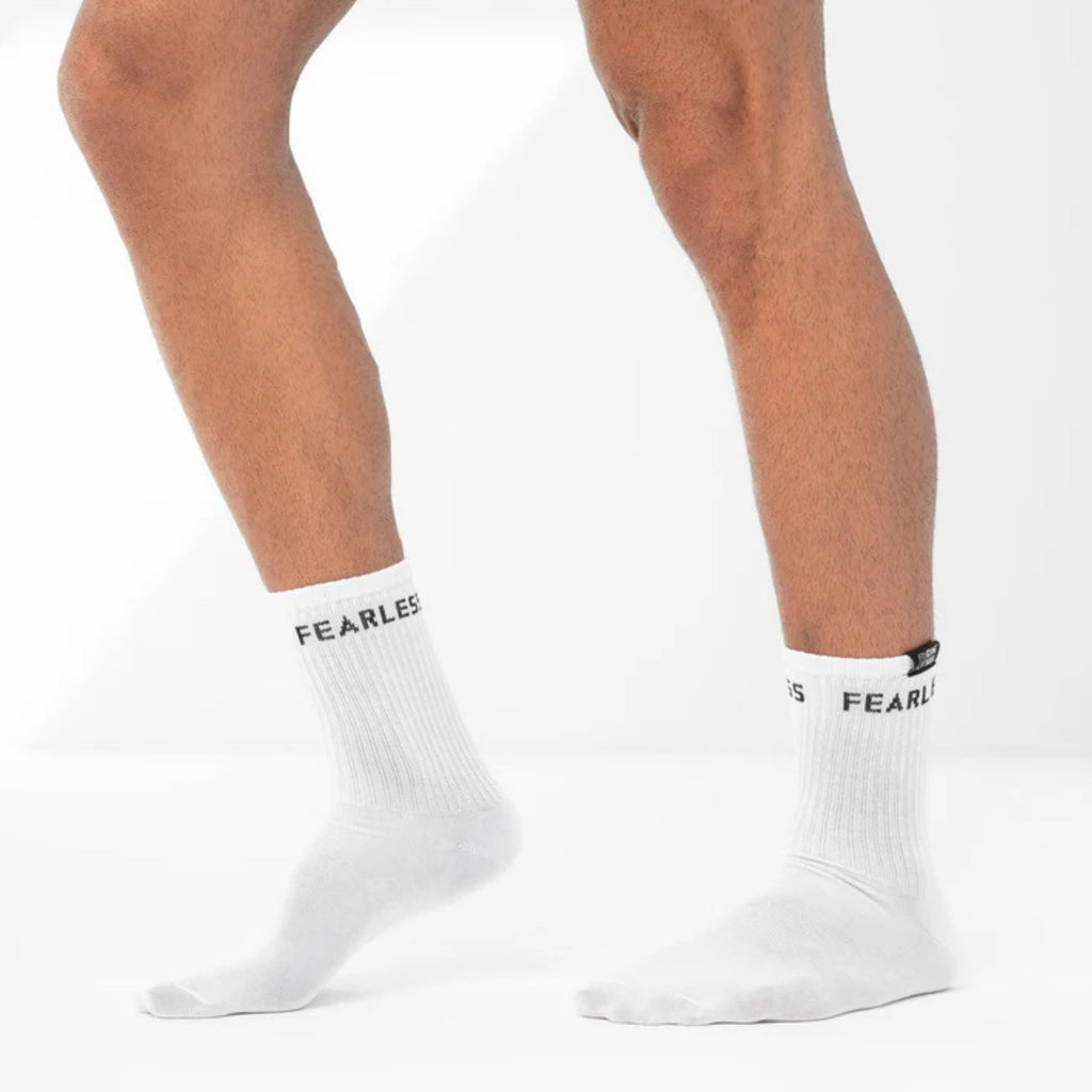 White socks with 'FEARLES' branding worn by a person on a white background