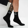 Black socks with 'Sam Club' text worn by a person on a white background