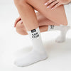 White socks with 'Sam Club' branding worn by a person on a light background