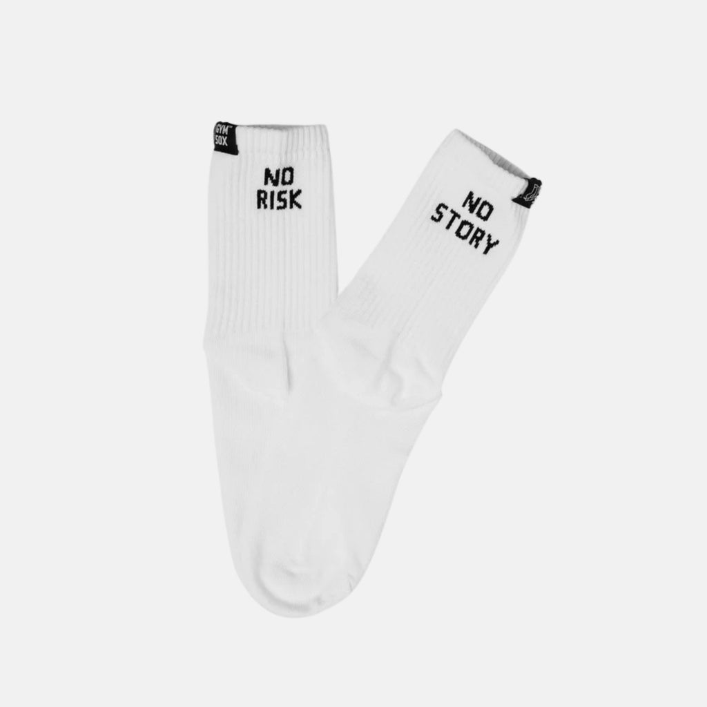 A pair of white crew socks with black text reading 'NO RISK' on one sock and 'NO STORY' on the other, displayed against a light gray background.