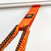 Close-up of an orange and black resistance band with a logo on a white background