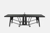 A black convertible ping-pong table with a wheeled base and central support frame, shown from the front on a white background.