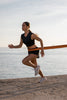 Person exercising outdoors with resistance bands by a body of water