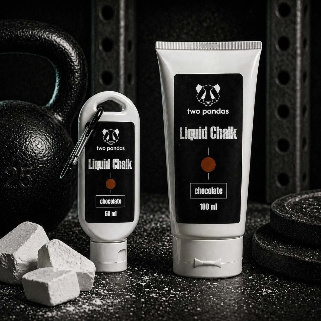 Two bottles of two pandas Liquid Chocolate Scented Chalk on a dark background with weights and chalk.