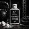 Two Pandas Panda Paws transparent liquid chalk bottle on a dark background with gym equipment.