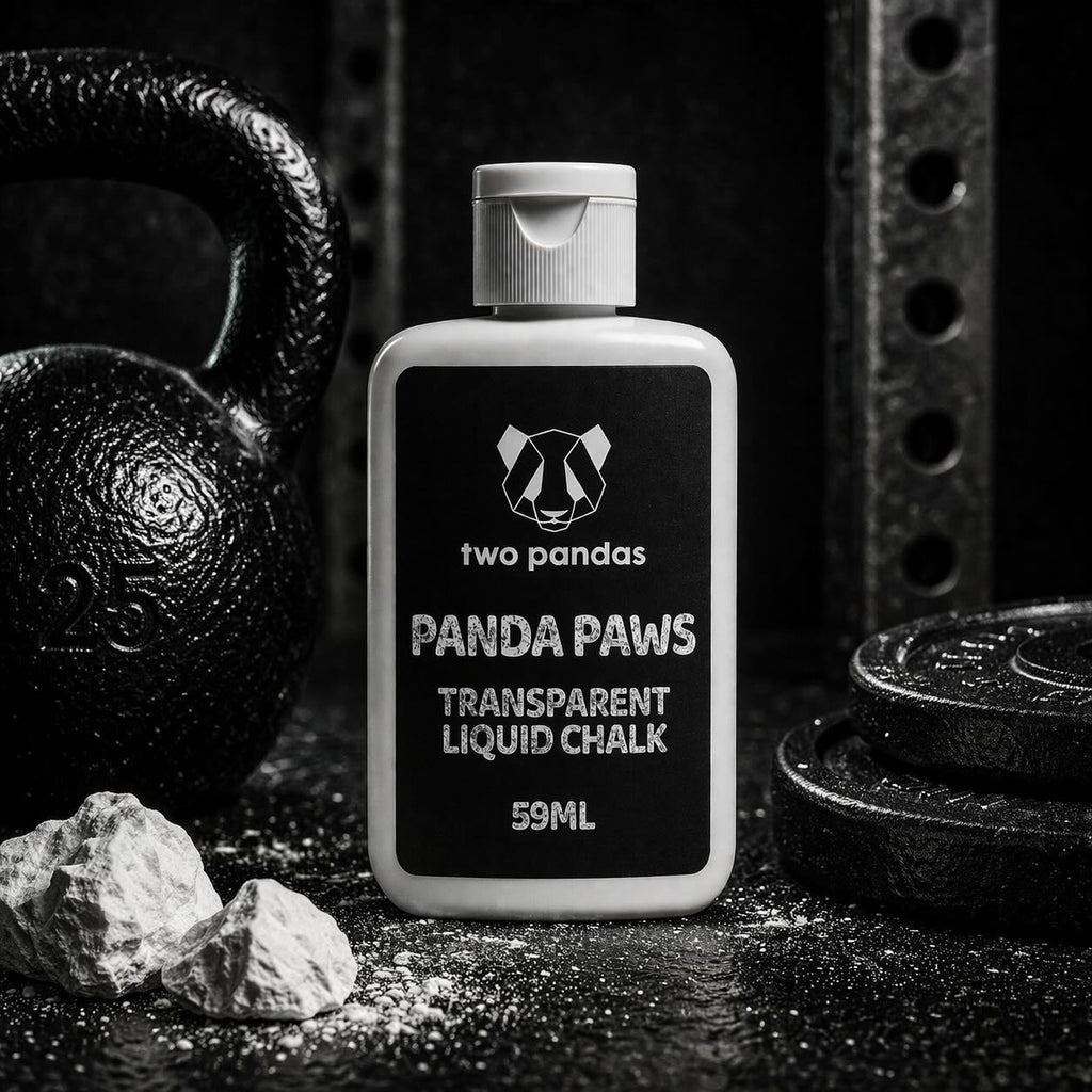 Two Pandas Panda Paws transparent liquid chalk bottle on a dark background with gym equipment.