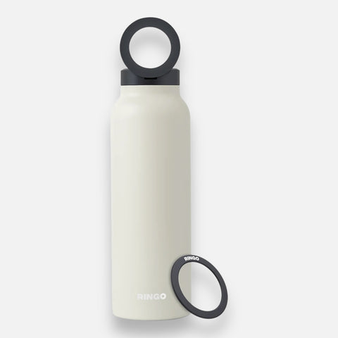 A beige-colored stainless steel water bottle with a black lid and additional black carrying loop.
