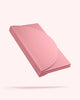 Folded pink Bala Compact yoga mat on a white background