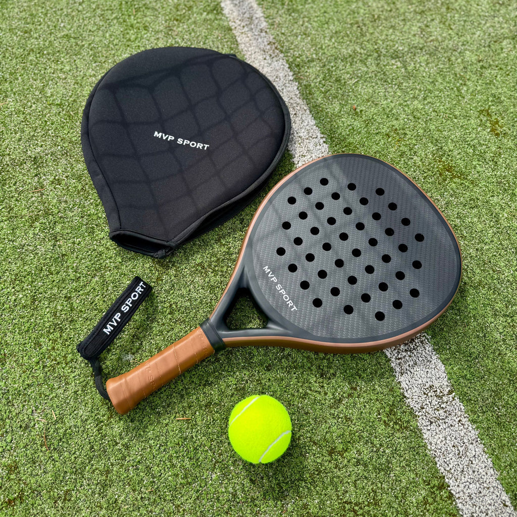 Padel Rackets Brown Paddle racket with brown handle and black paddle on grass court ...