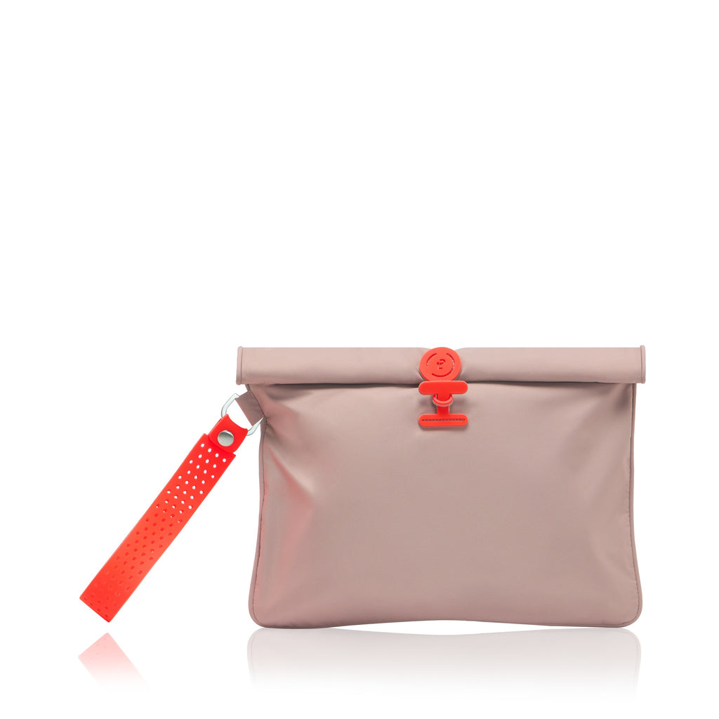 A dusty pink nylon pouch with a roll-top closure, featuring a bright red plastic clasp and a matching red perforated wrist strap, shown on a white background with a soft reflection.