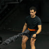 Man using resistance bands for exercise on a dark background