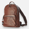 A brown leather backpack with a front pocket and visible zipper closure. The backpack features an embossed design on the front pocket.