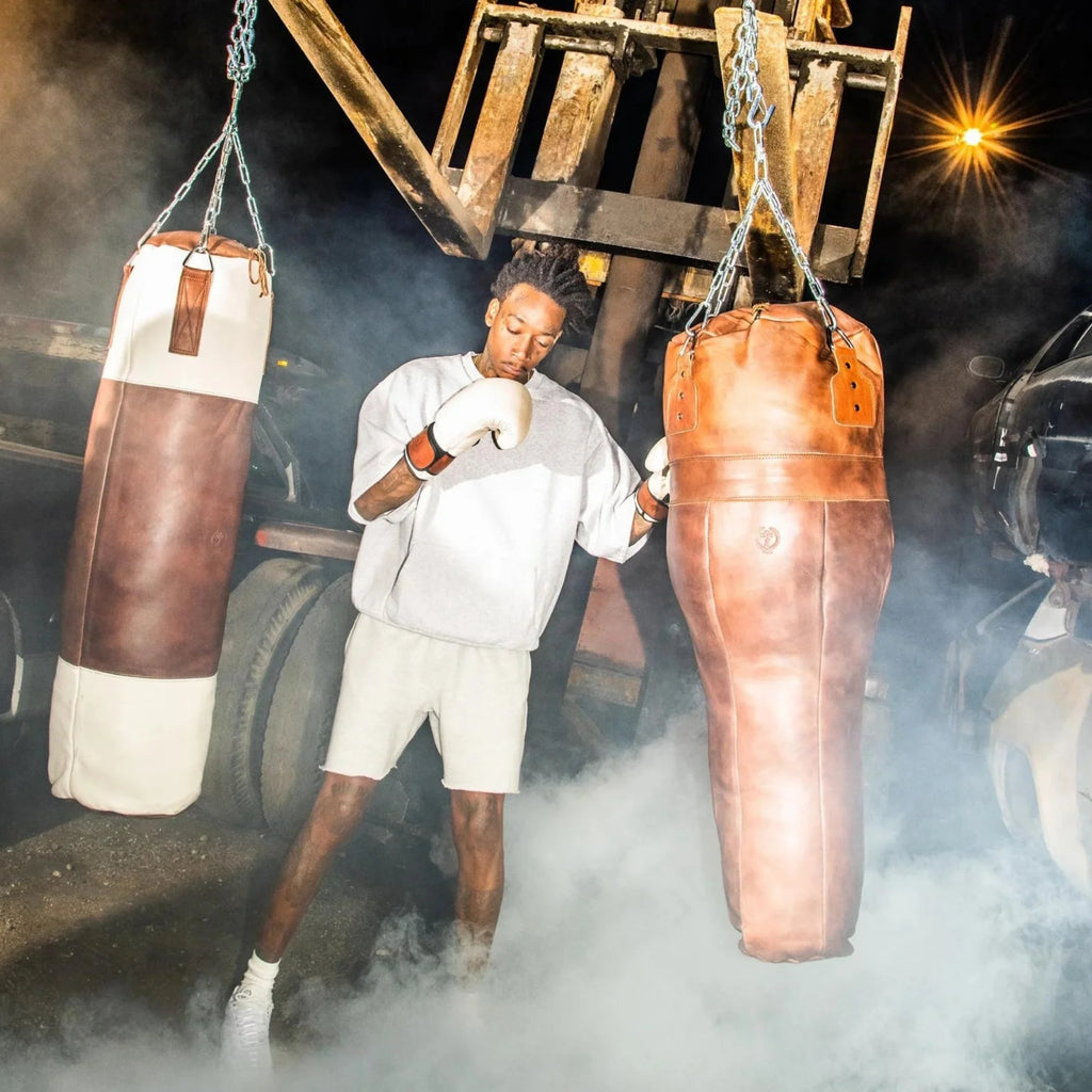 Person training with vintage boxing bags in a smoky environment