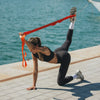 Woman exercising with a stretch band by the water