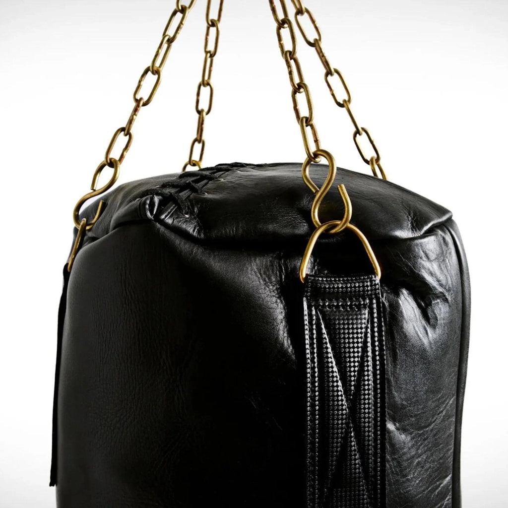 Black punching bag with gold chains on a white background
