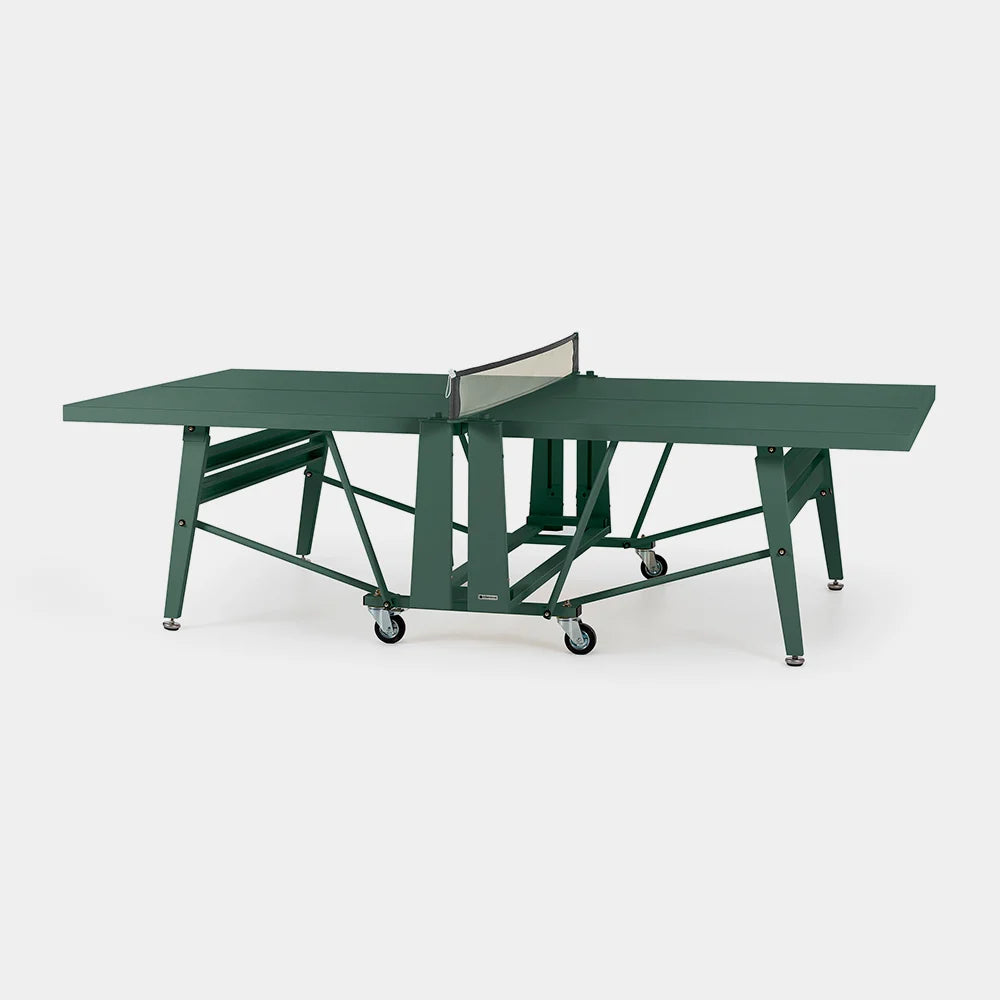 A green portable folding table tennis table with a net and caster wheels, shown on a light gray background.