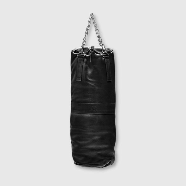Black leather punching bag with chain on a light gray background
