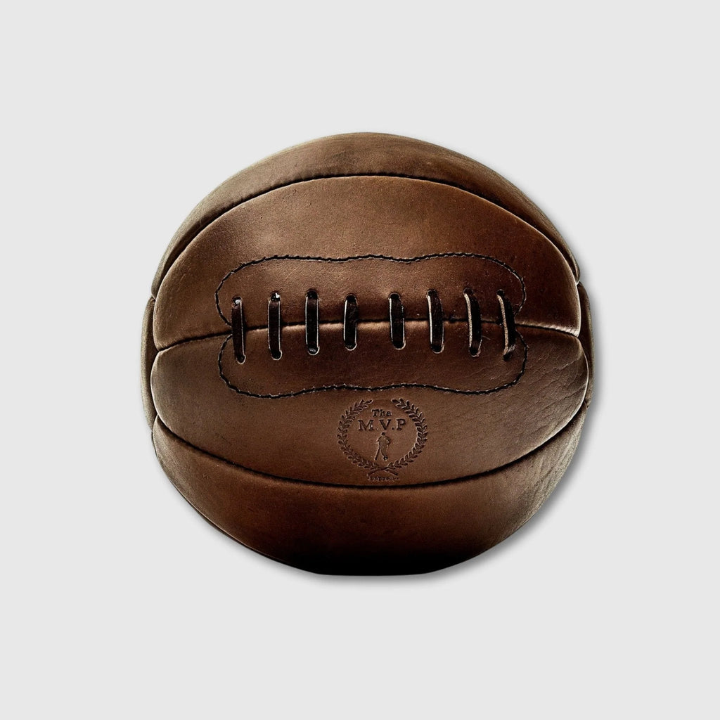 Brown leather medicine ball with 'MVP' emblem on a light gray background