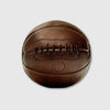 Brown leather medicine ball with 'MVP' emblem on a light gray background